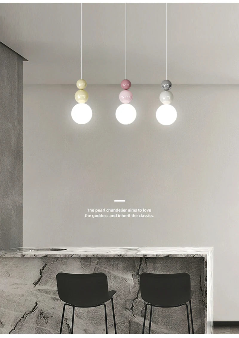 Nordic pendant lights: modern LED hanging lamps with cream, pink, and gray bead accents (3-pack) over a marble counter.