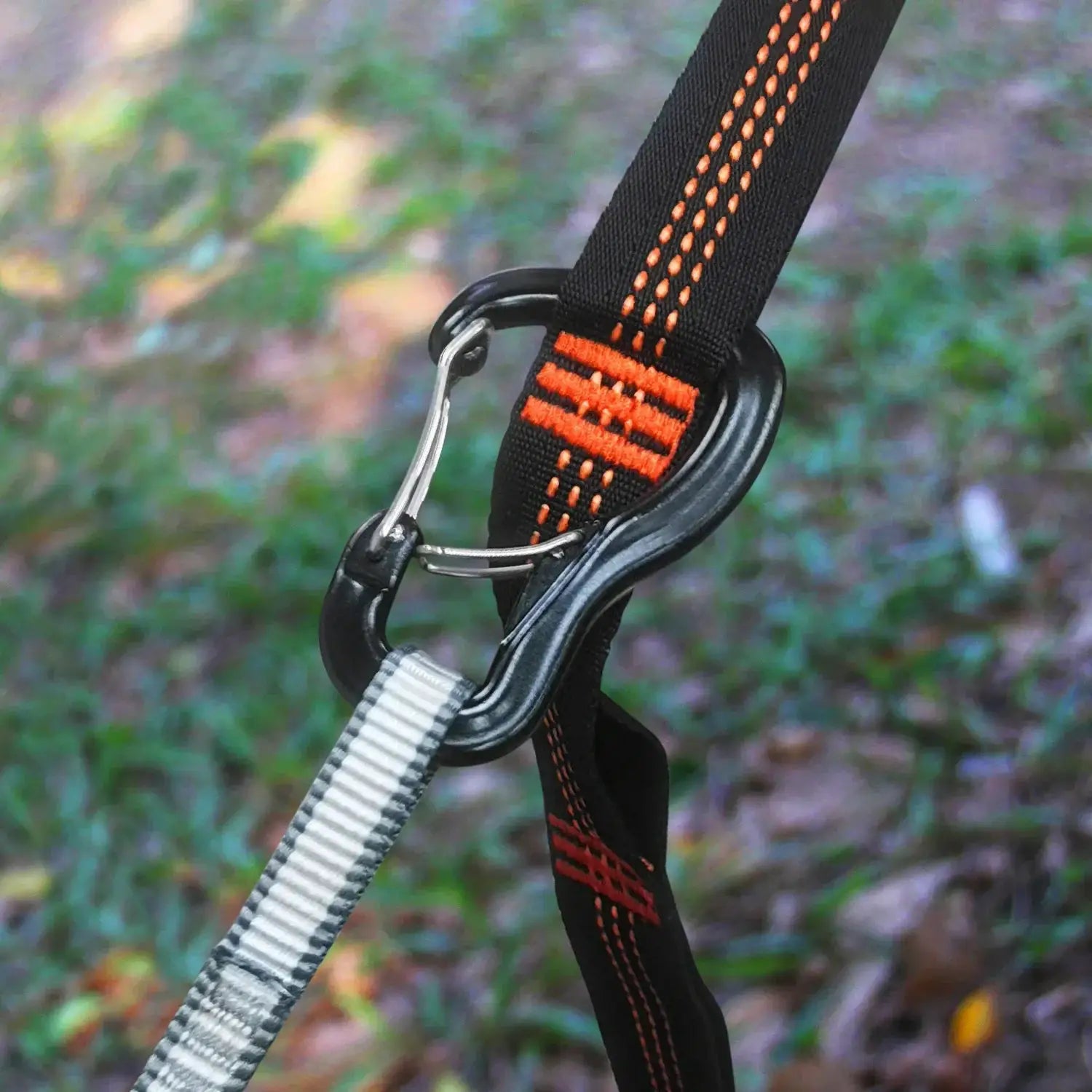 Outdoor hammock strap with double locking buckle and aluminum hardware; black strap with orange stitching and carabiner