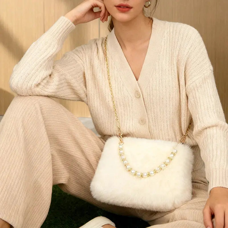 Pearl rabbit fur handbag with gold chain crossbody strap; white fluffy compact bag