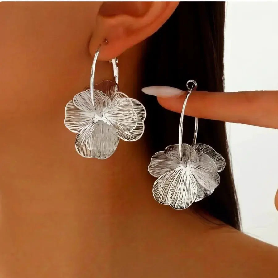 Pair of silver floral hoop earrings with layered petals by Simples Market