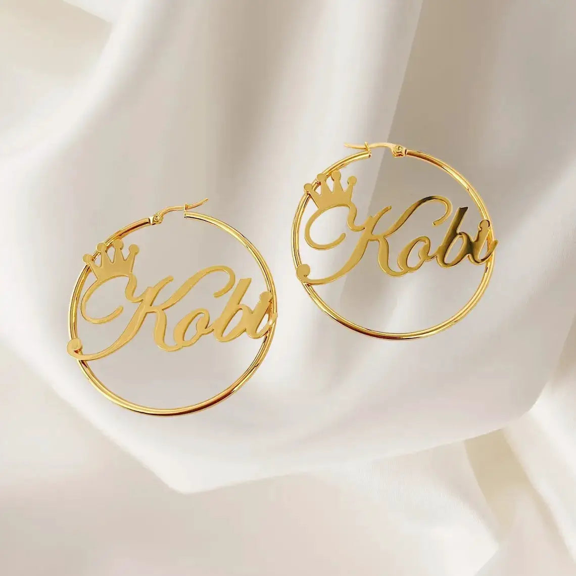 Gold-tone crown-name hoop earrings, two large round hoops with script name design