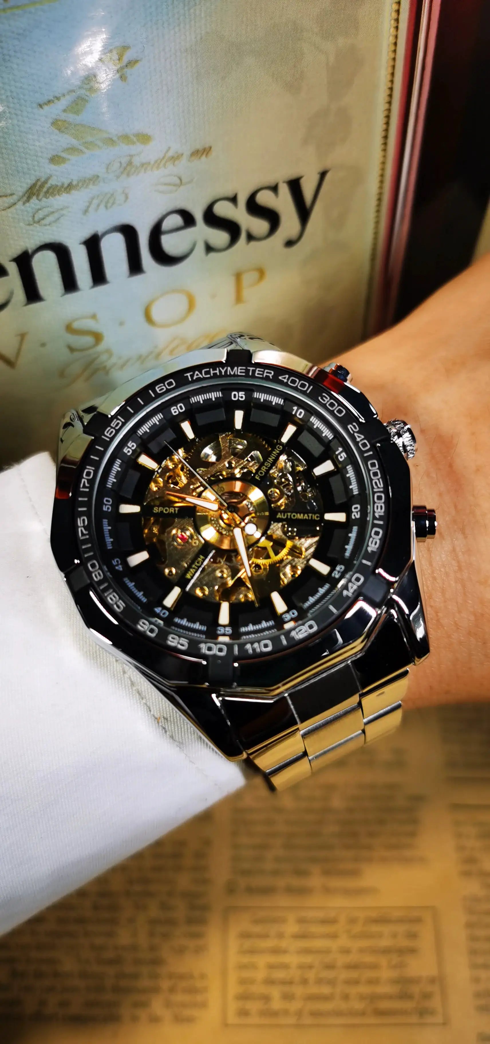 Forsining skeleton watch for men with stainless steel strap, luminous hands, and visible gold gears
