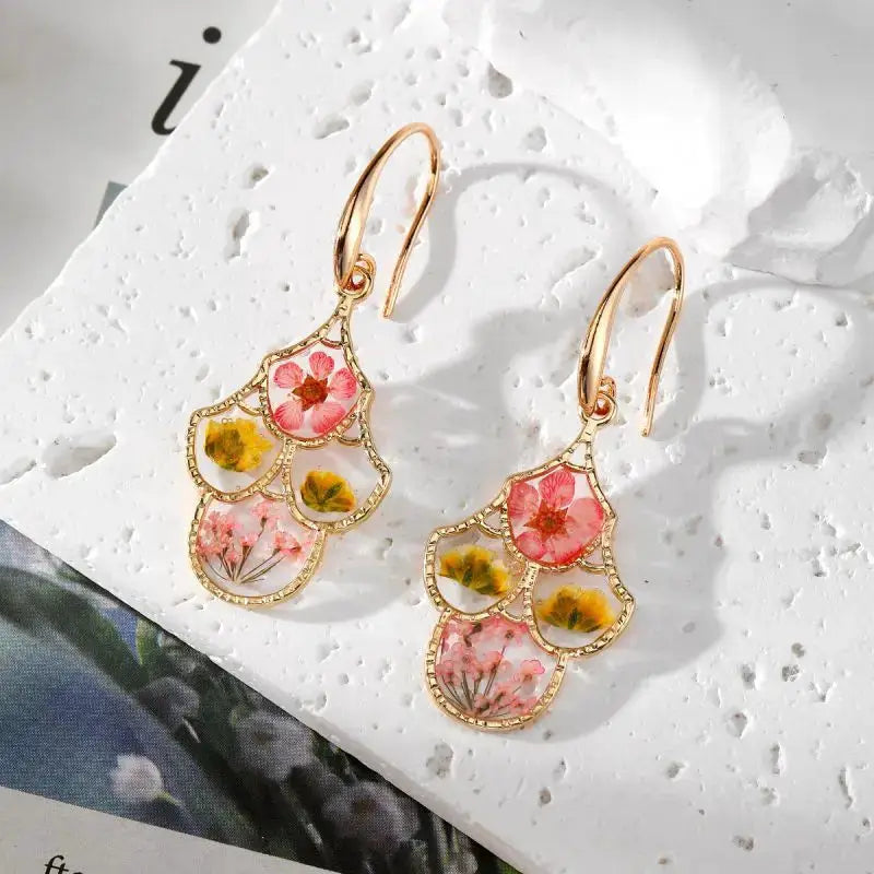 Natural flower dangle earrings with epoxy resin pressed blossoms in pink and yellow, gold-tone frames