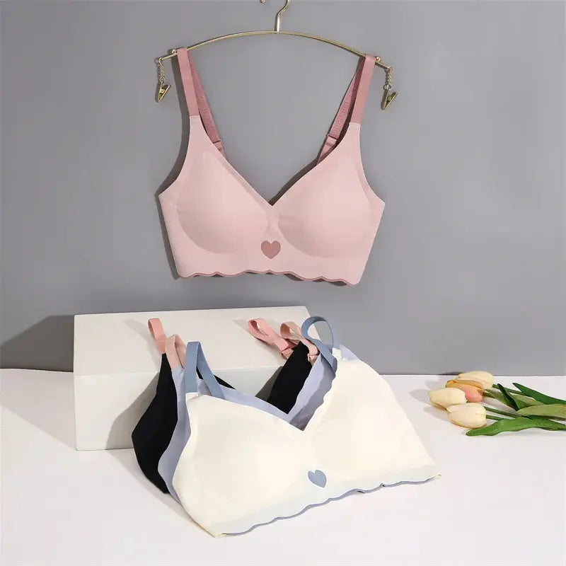 Pink seamless bralette with adjustable straps; scalloped hem and heart emblem, set of 3 color variants shown