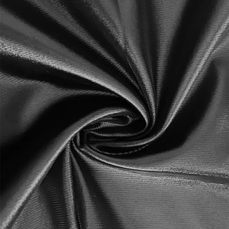 Faux leather mini skirt fabric close-up in black with glossy sheen