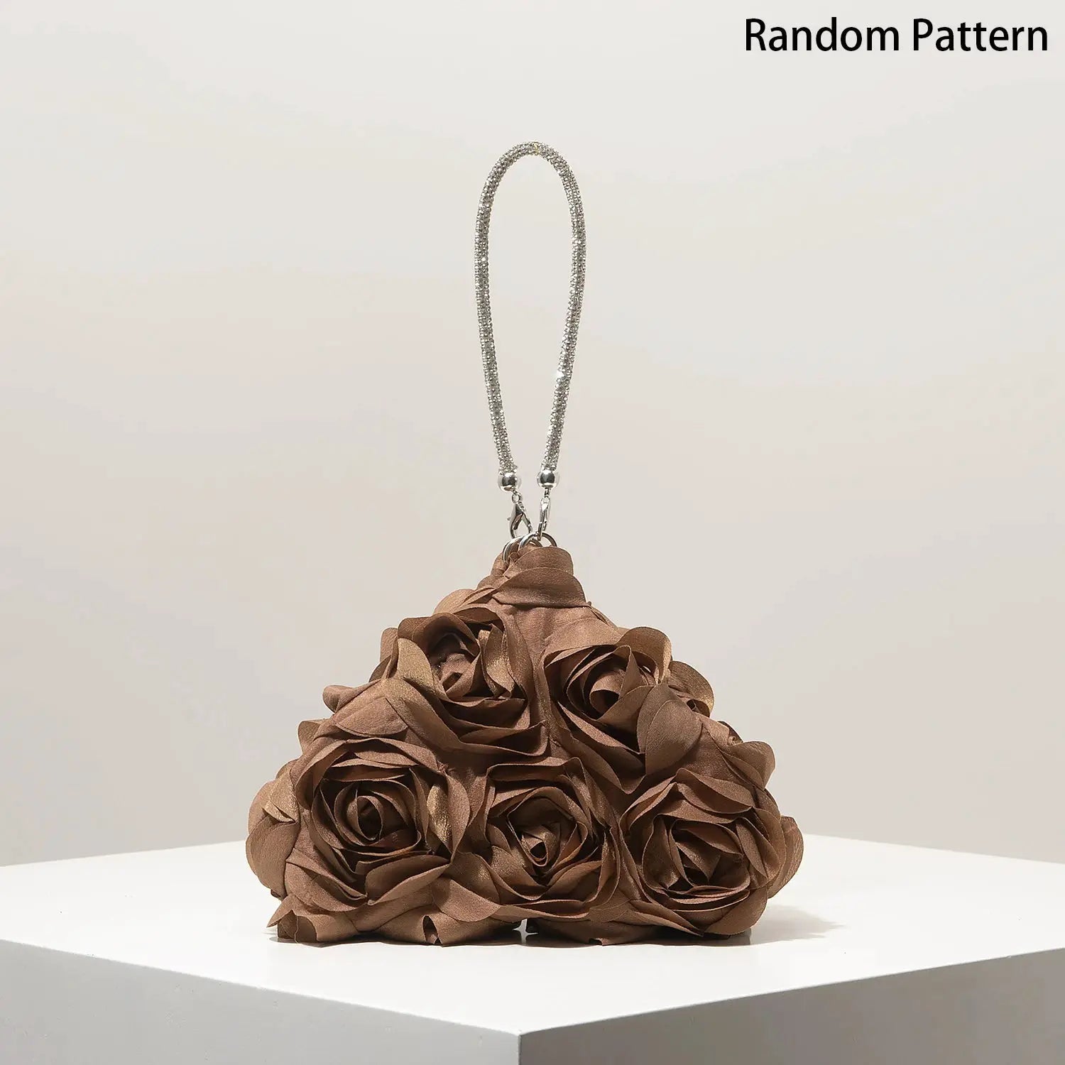 Mini floral bouquet purse in brown rose tones with a silver beaded strap, displayed on a white pedestal