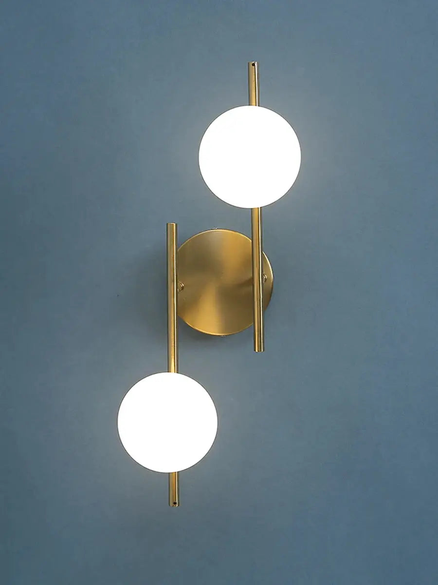 Modern LED wall lamp in gold brass finish with two milky-glass globes on vertical rods