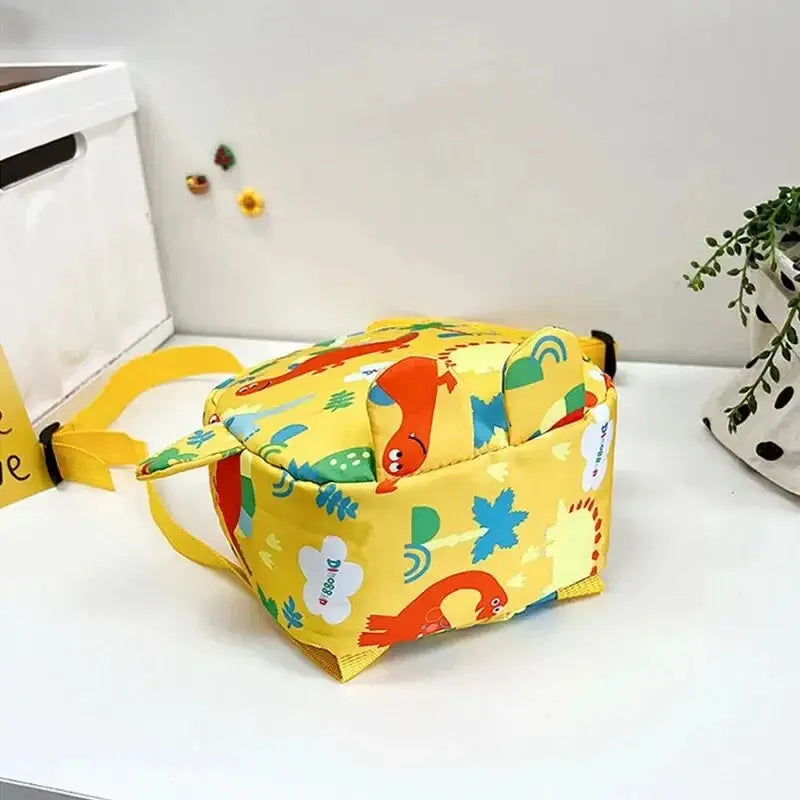Cute cartoon dinosaur kids backpack, bright yellow with adjustable straps for boys and girls.