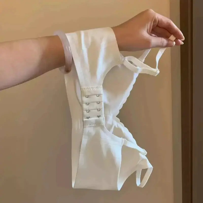 White women's sports bra with side hook closures; lightweight, comfortable support.