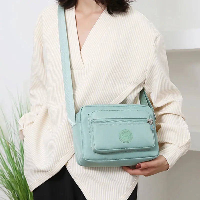 Simples Market pale blue crossbody bag with front zip pocket and long adjustable strap