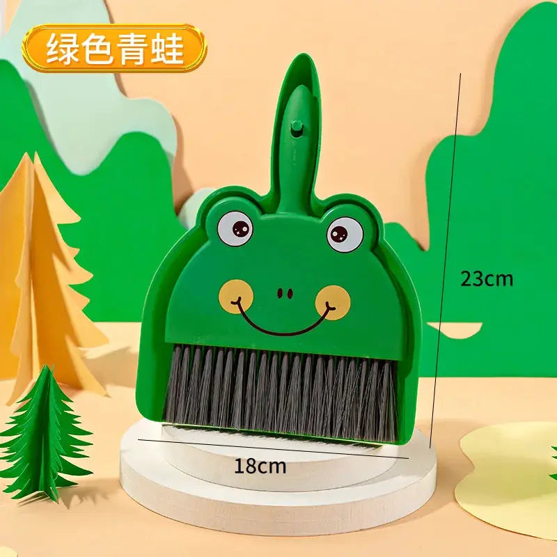 Mini desk broom by Simples Market, frog-themed green body with black bristles, 23 cm tall