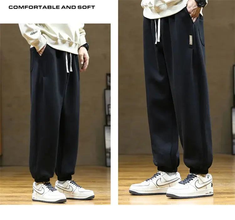 Men's black sweatpants with drawstring waist, loose jogger fit and cuffed ankles
