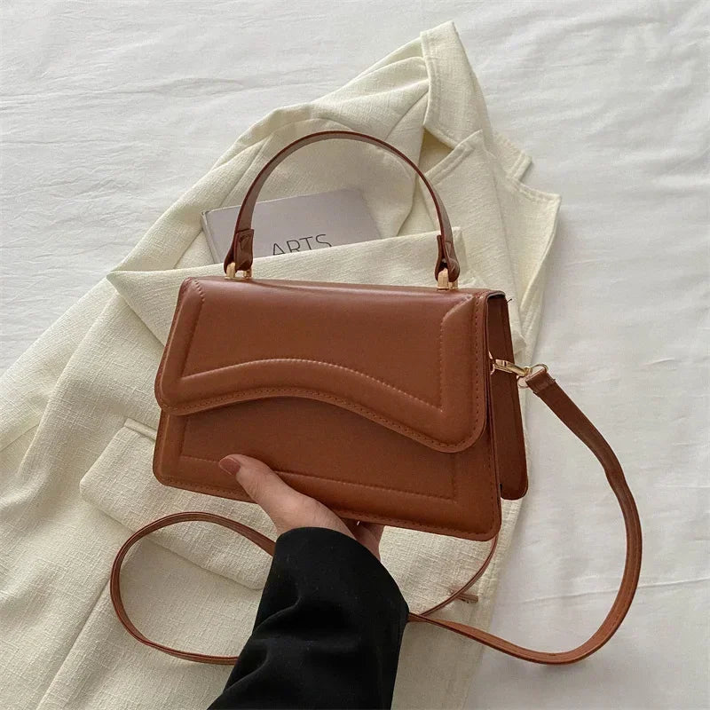 Brown PU leather handbag with top handle and long crossbody strap