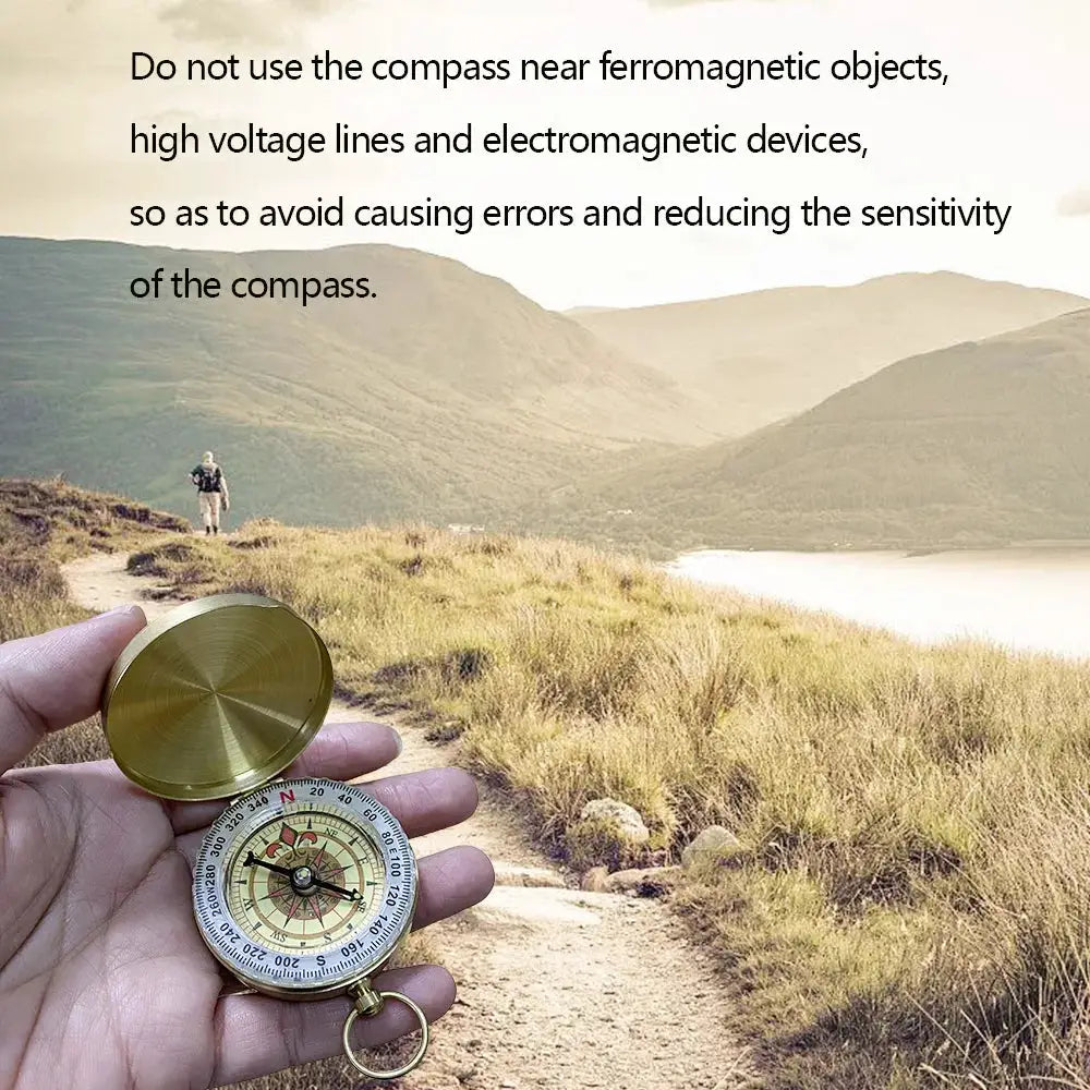 Brass pocket compass with open lid, water-resistant handheld camping navigation device by Simples Market.