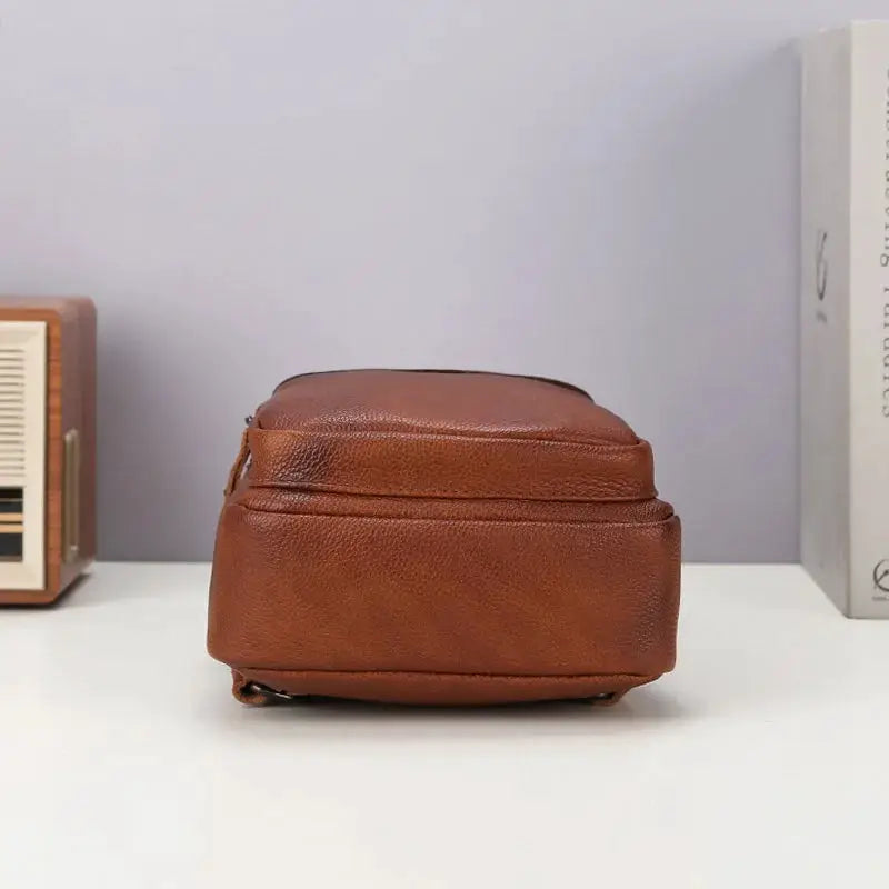 Brown genuine top-grain leather chest bag for men; compact crossbody with top zipper.