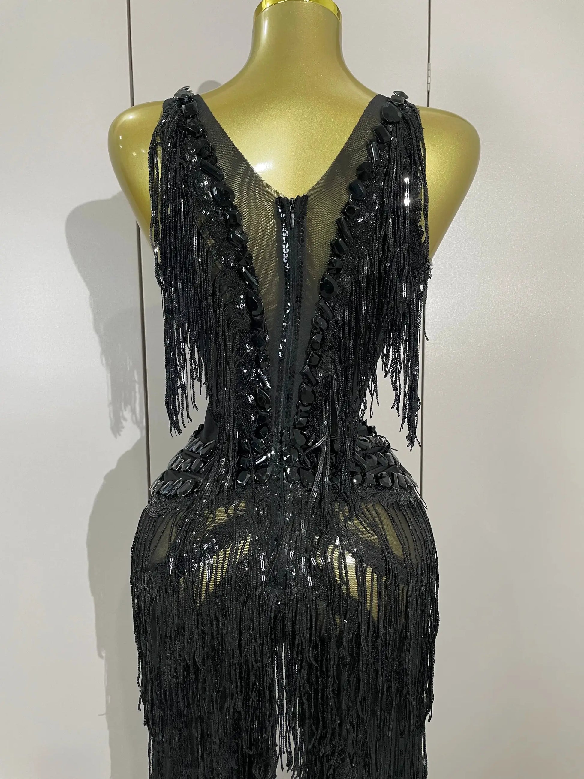 Black rhinestone sequined fringe jumpsuit on mannequin, back view with long fringe strands