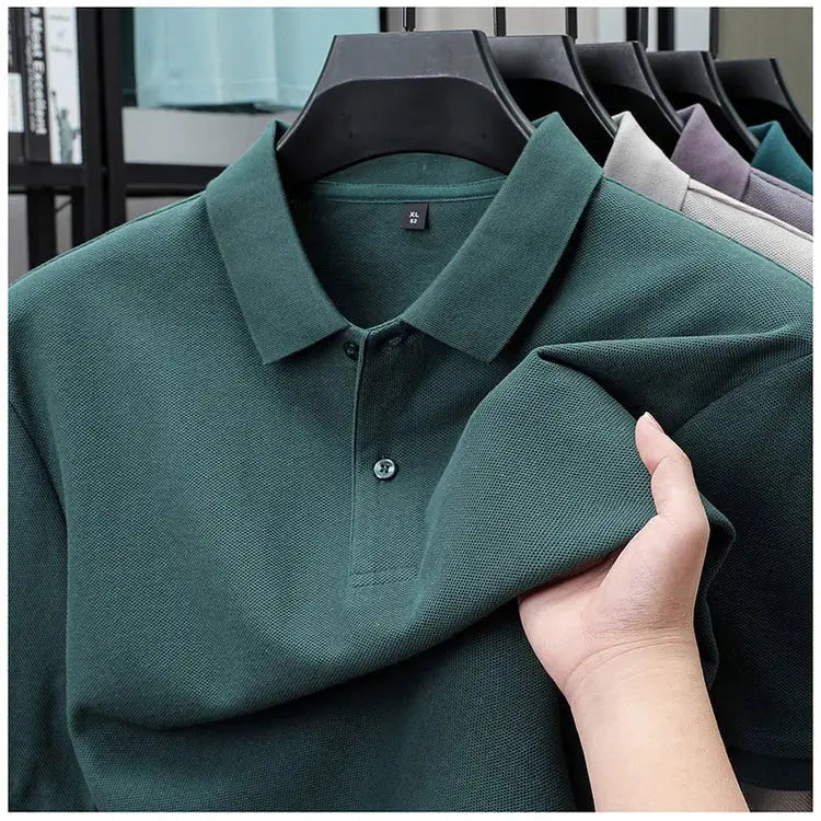 Men's green polo shirt on hanger; textured knit, button placket, with other colors visible in background