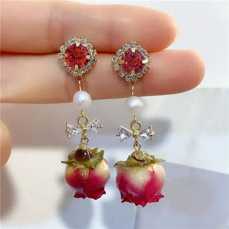 Unique red rose earrings with crystal halo, pearl drop, bow accents, and epoxy resin rose pendants