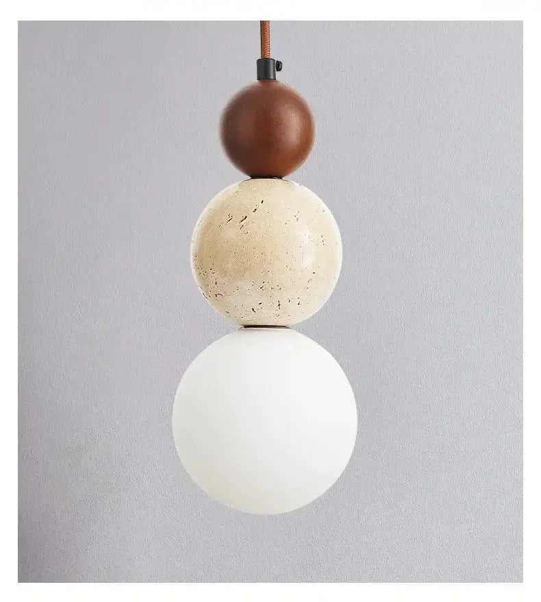 Pendant lamp by Simples Market with three stacked spheres: brown wood, beige stone, white glass.