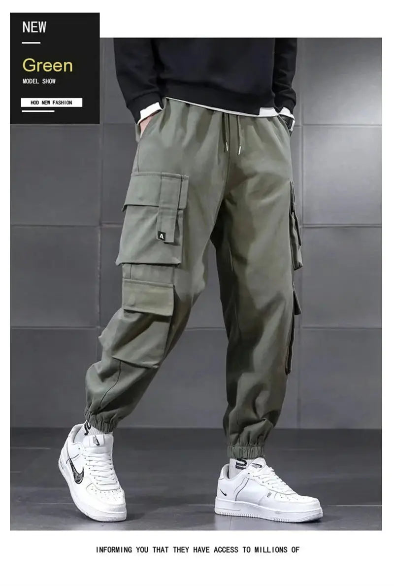 Men's olive green cargo pants with multiple pockets, drawstring waist, and elastic cuffs.