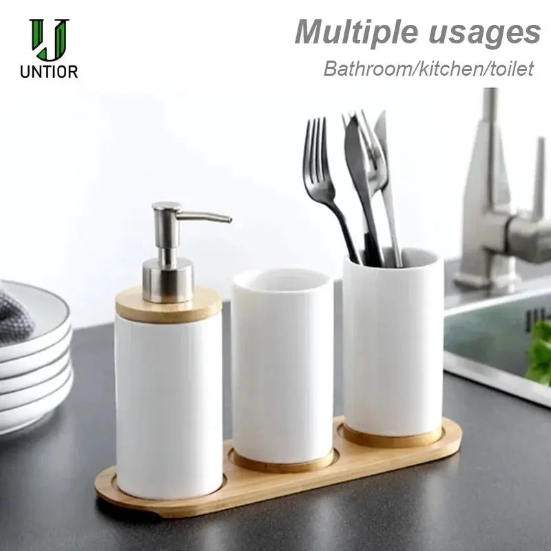 Ceramic bathroom accessories set with white dispenser, toothbrush holder and tumbler on a wooden tray