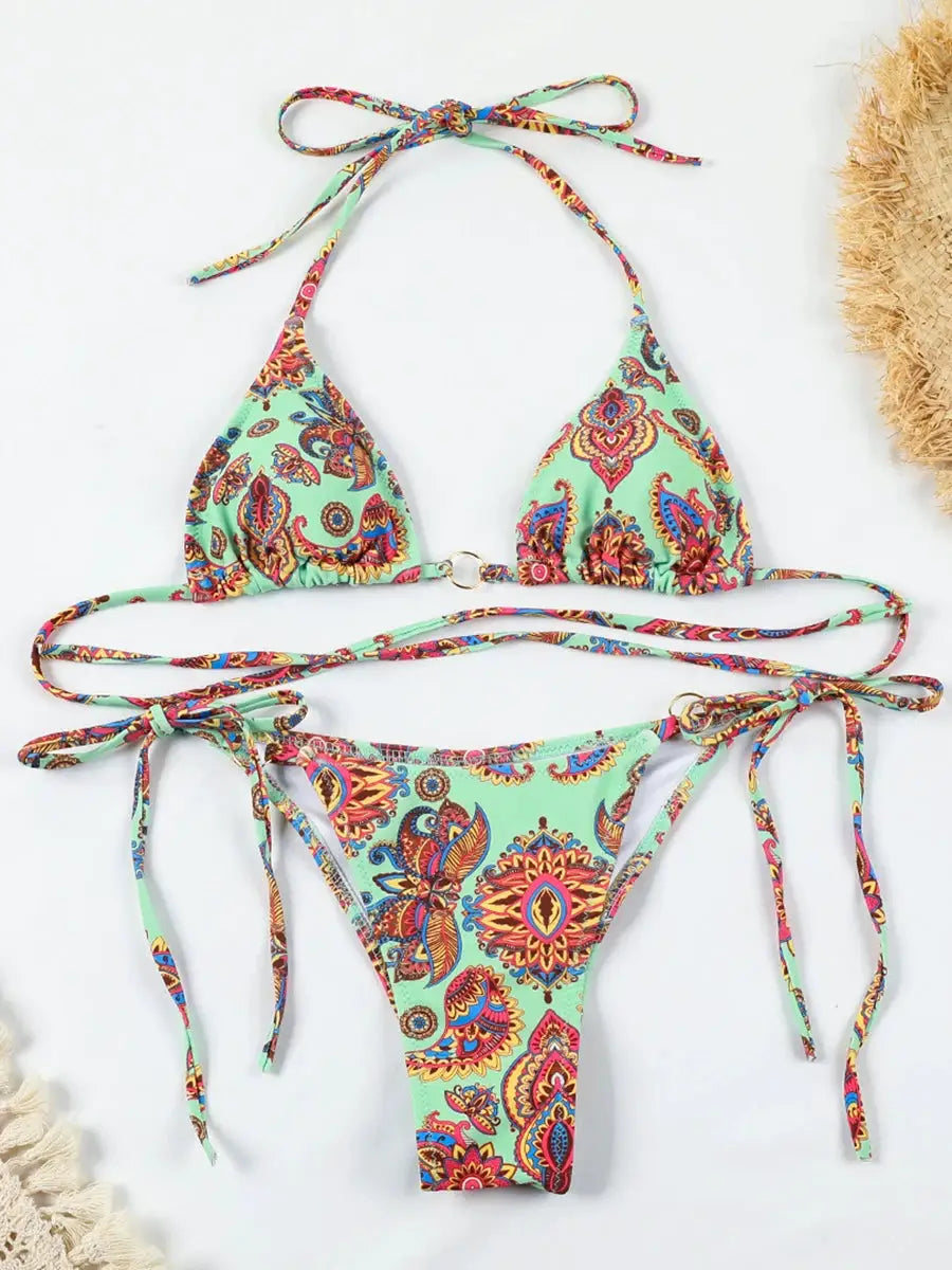 Two-piece bikini set in mint green with colorful paisley print; halter top and tie-side bottoms.