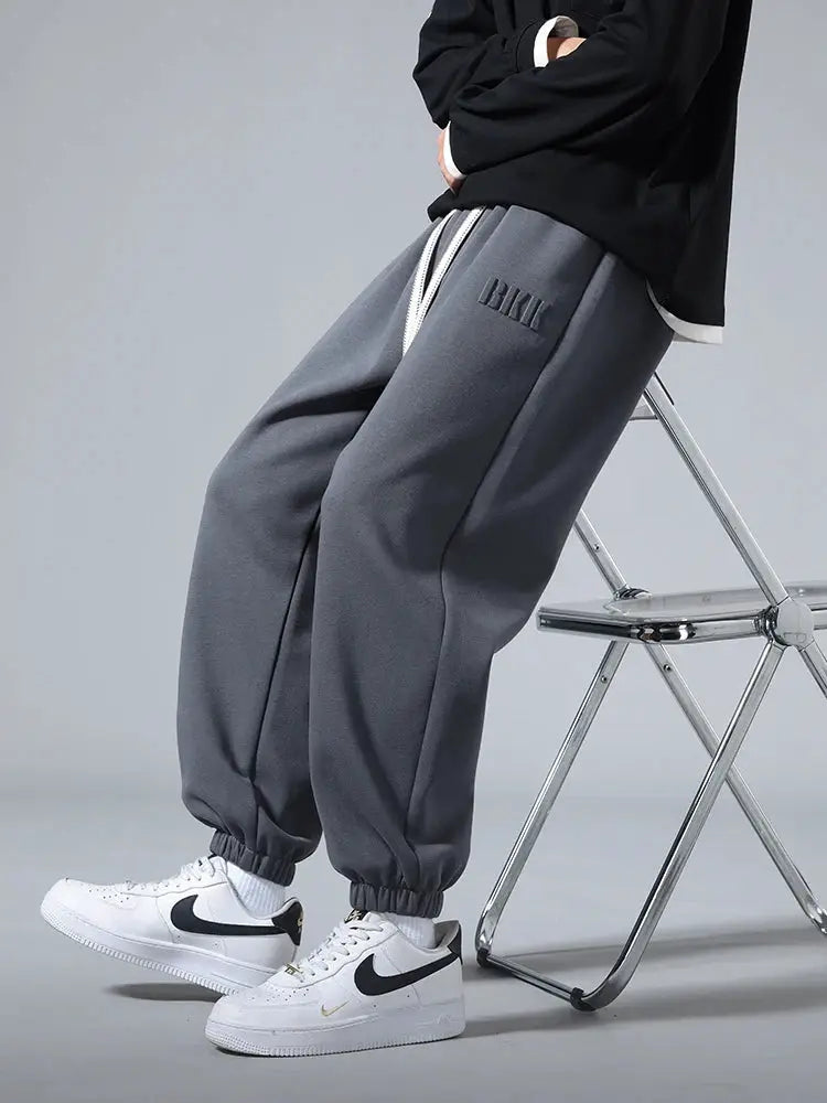 Men's baggy gray jogger pants with BMK logo, cotton/poly blend, white drawstring, cuffed ankles