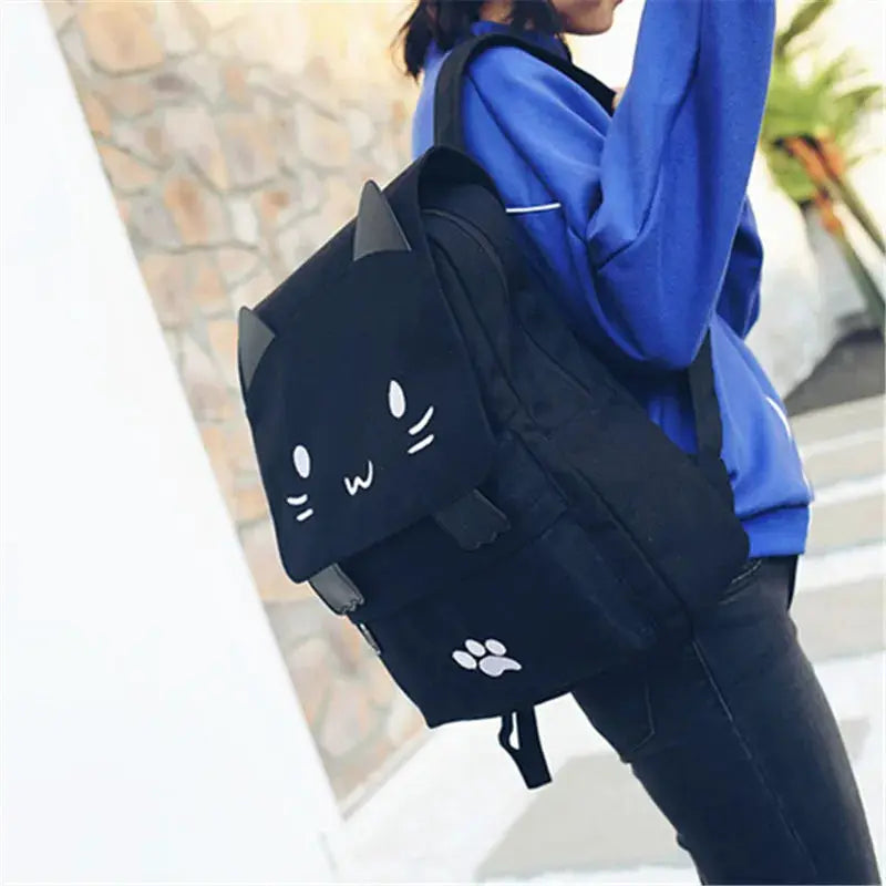 Black 3D cat backpack with ears, whiskered face and paw print, large-capacity school bag.