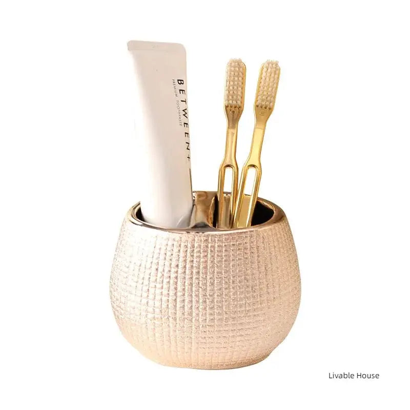 Rose gold ceramic bathroom accessories set with toothbrush holder, toothpaste tube and two gold toothbrushes