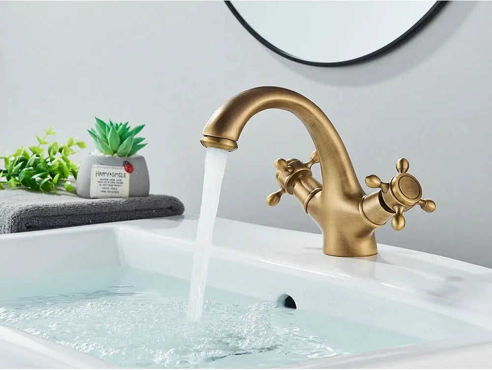Antique brass bathroom faucet with two cross handles, deck-mounted hot and cold water mixer.