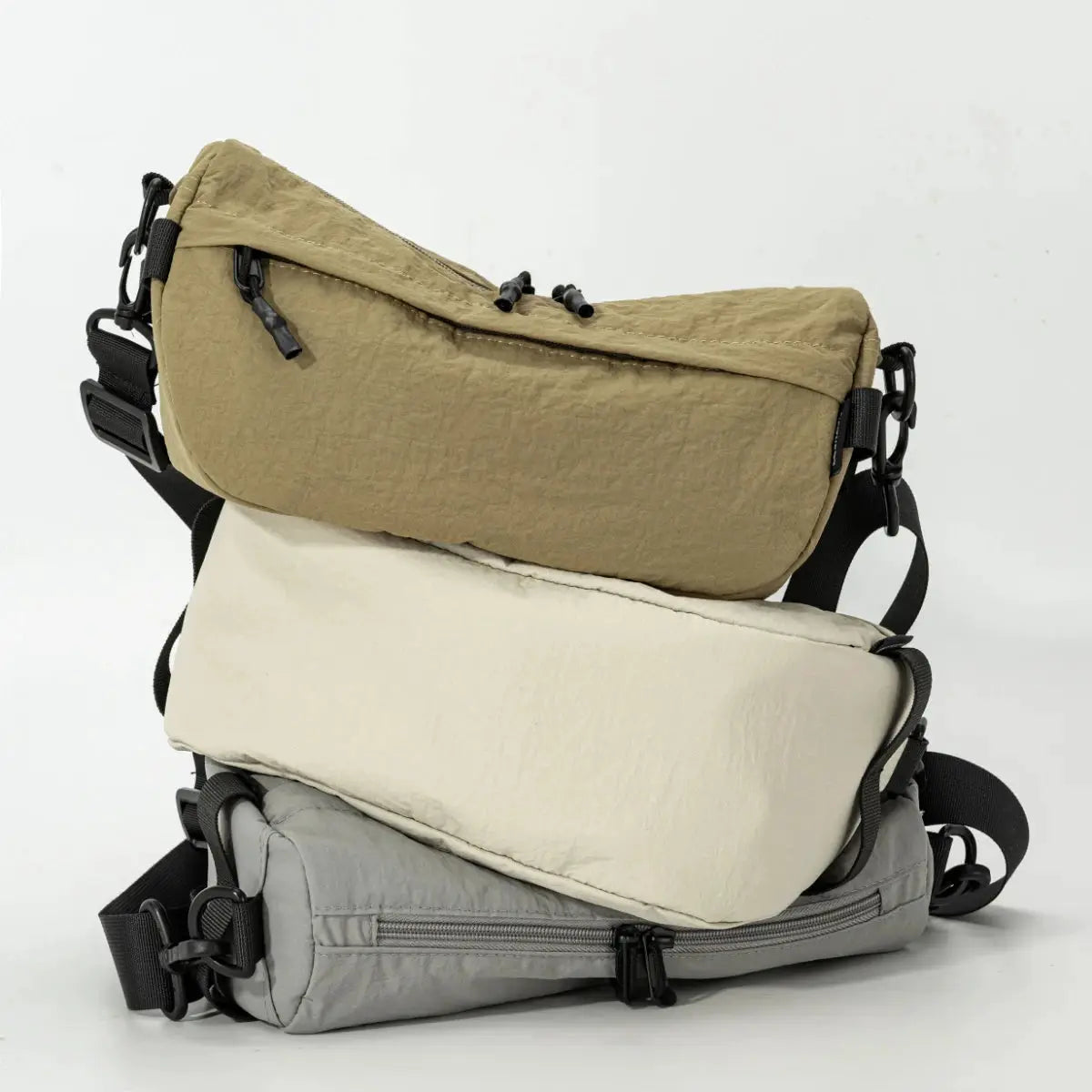 Three Japanese-style waterproof nylon crossbody bags in beige, cream, and gray with multiple pockets.
