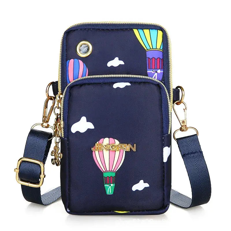Mobile phone crossbody bag by Simples Market in navy with gold hardware and a gold logo badge, featuring balloon print.