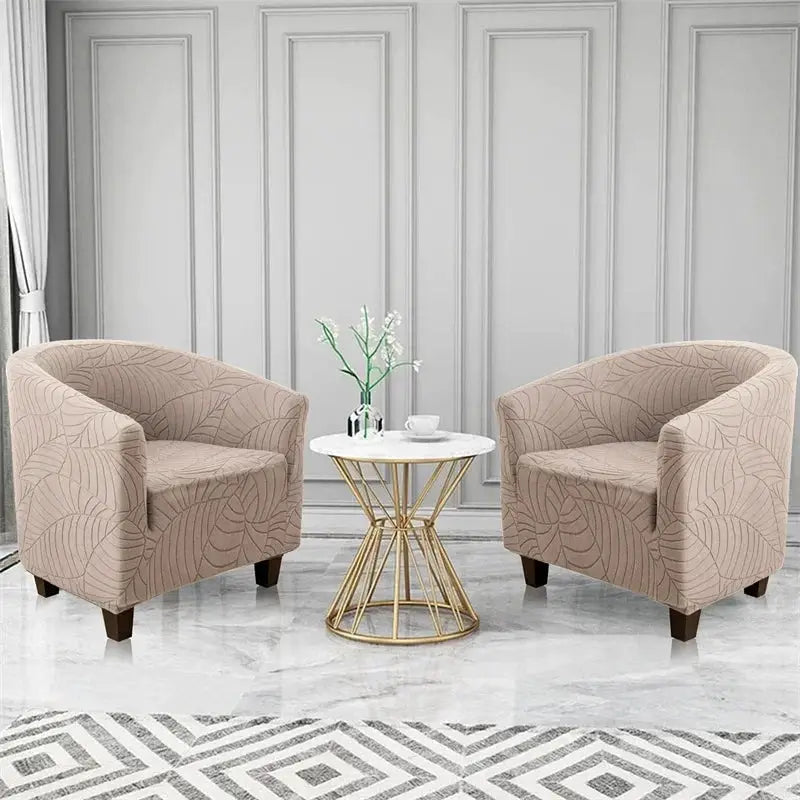 Elastic leaf-jacquard club chair slipcovers in beige on two single armchairs in a living room.