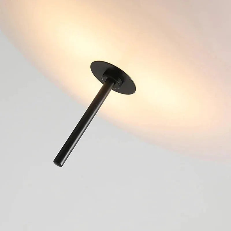 Nordic LED pendant light by Simples Market with black flying-saucer design and warm ambient glow.