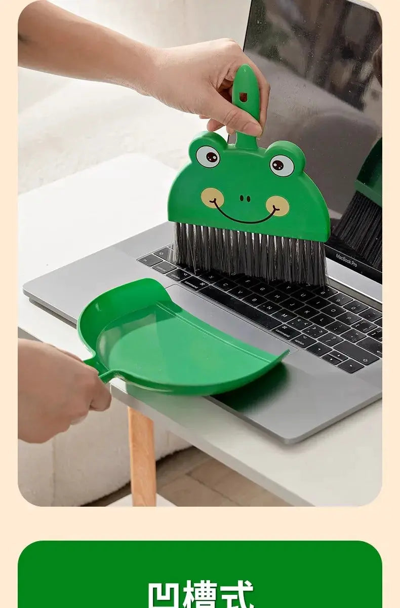 Simples Market frog-face mini desk broom and green dustpan set with bristles, shown on a laptop