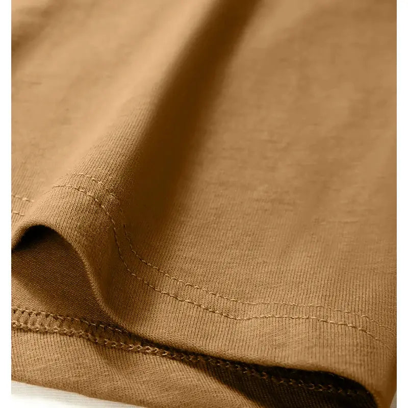 Tan cotton men's boxer shorts fabric close-up with visible stitching