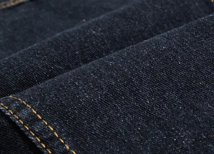 Denim jeans vest by Simples Market; close-up of dark blue denim fabric with yellow stitching.