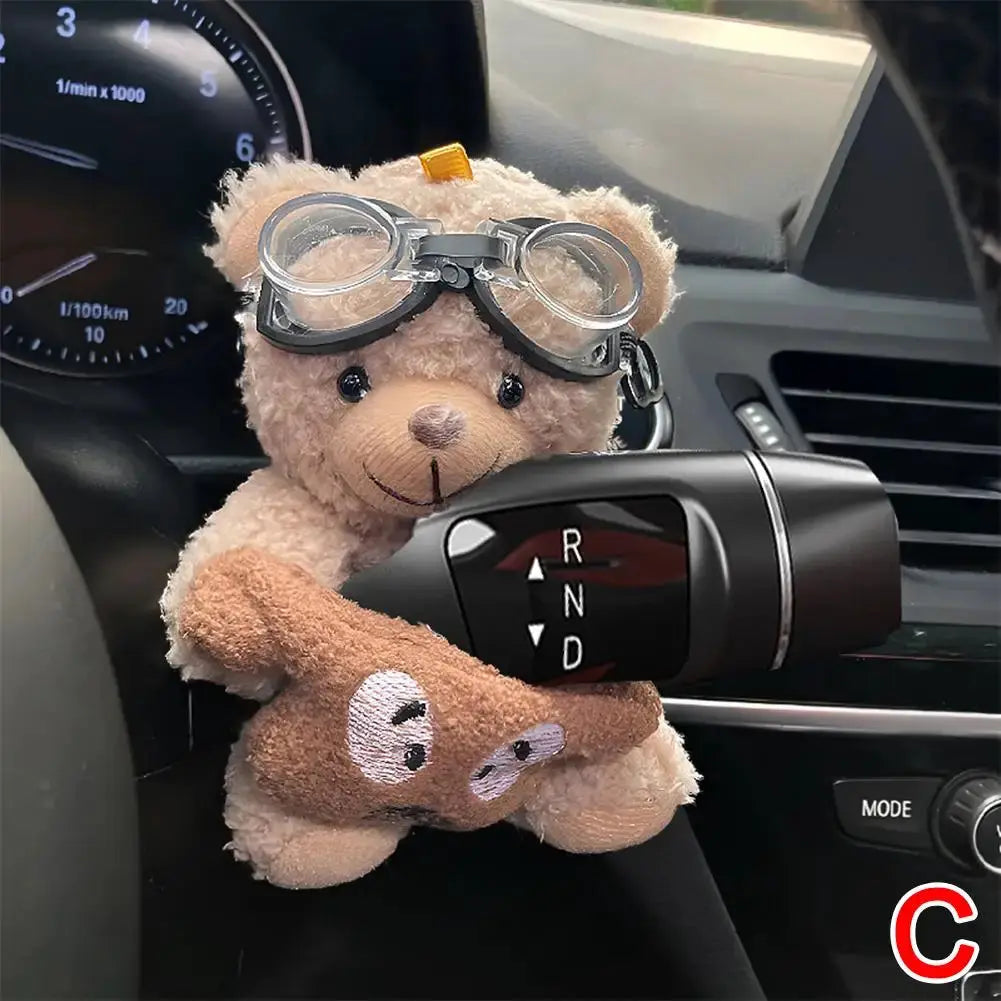 Pilot Bear plush car decor with goggles on its head, perched near the gear shift