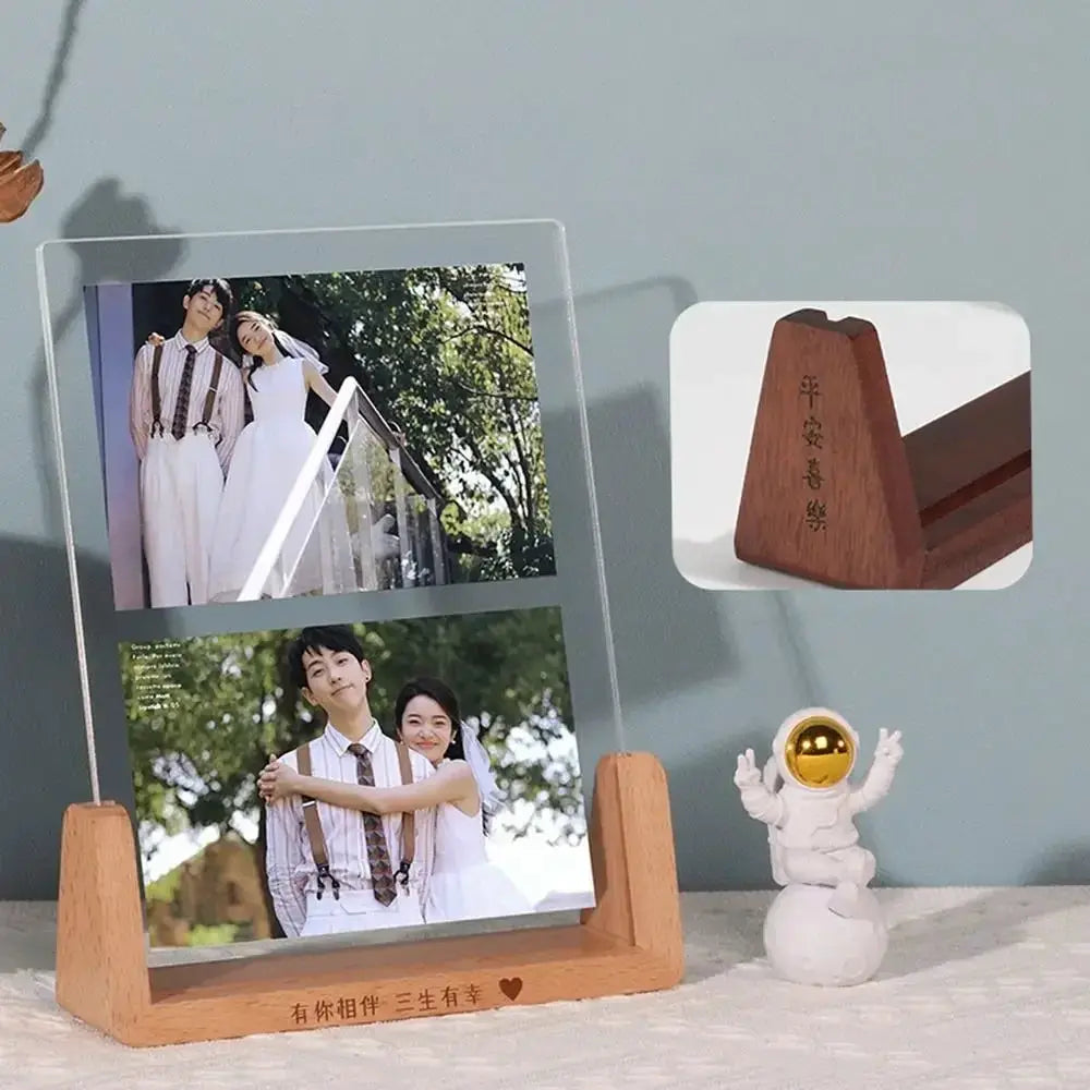 Acrylic U-shape photo frame with walnut/beech wood base holding two wedding photos on a desk