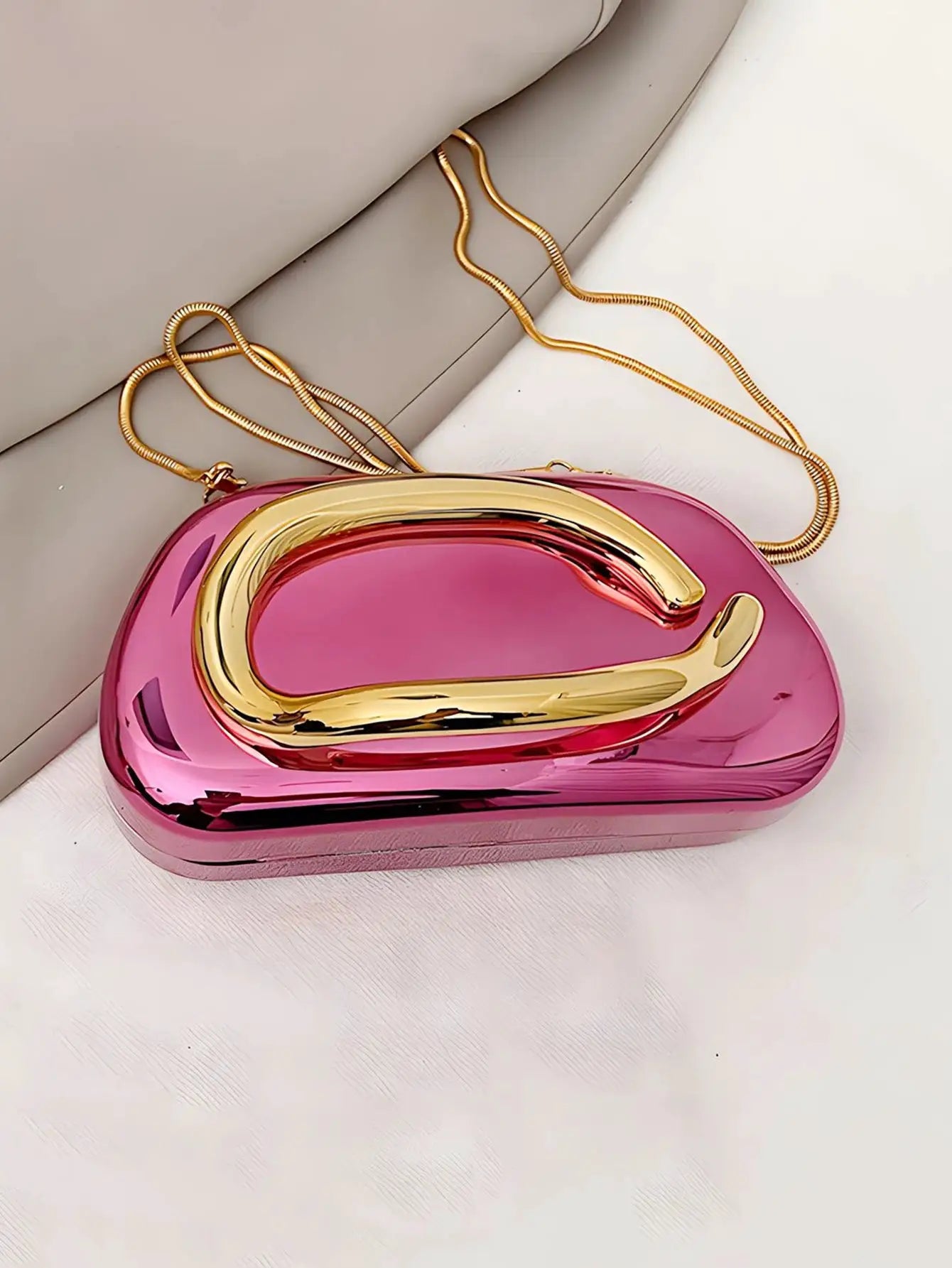 Pink acrylic box-shaped crossbody bag with gold-tone curved clasp and chain strap