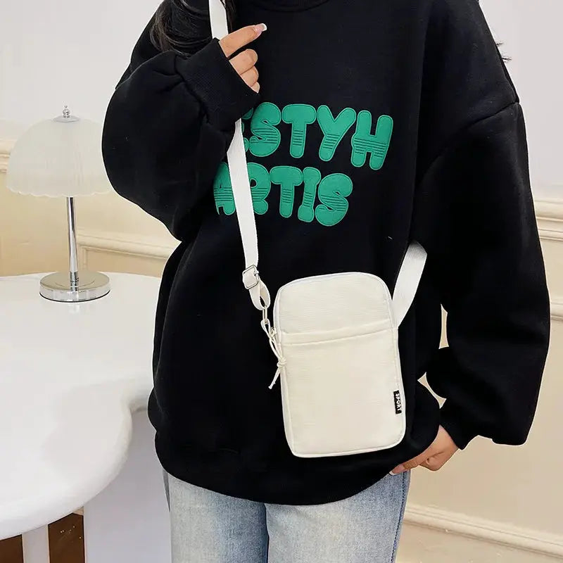 Simples Market white vertical shoulder bag with front pocket and adjustable strap