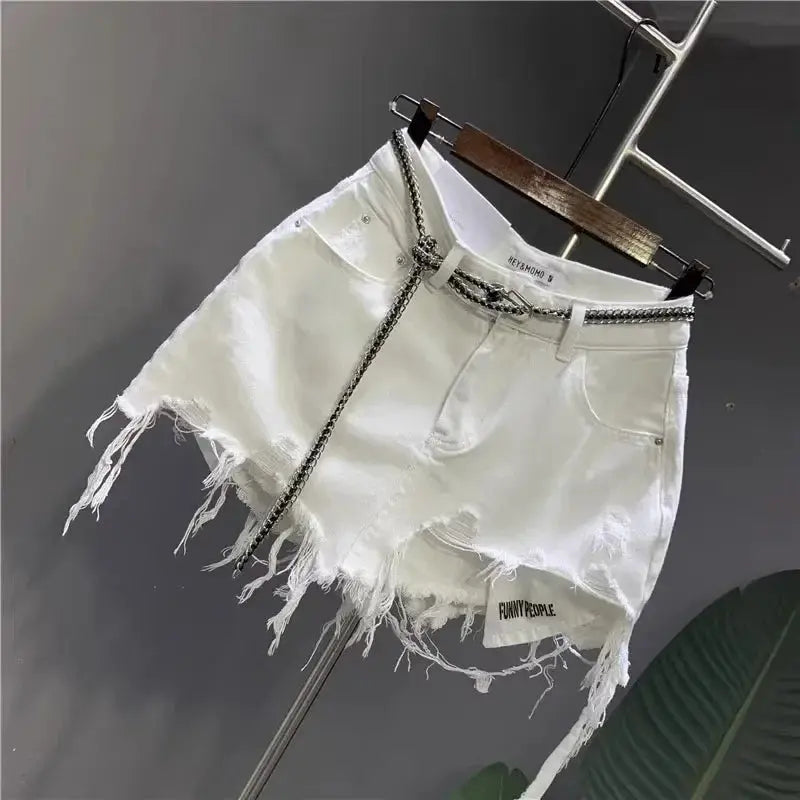 White denim mini skirt with frayed raw hem, front pockets, and a metal chain belt; Funny People patch.