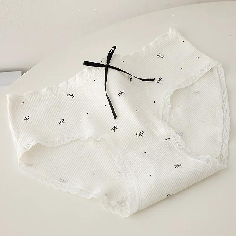 Women’s white ribbed panty with lace trim and black bow accent