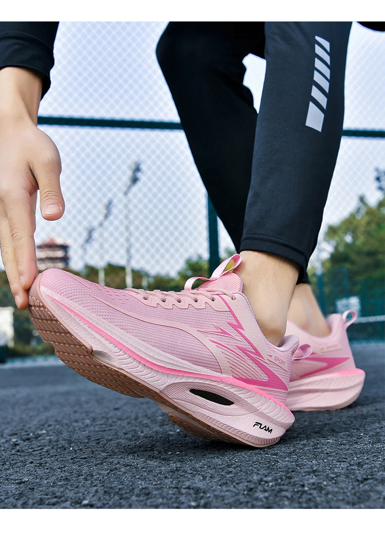 Pink women's running sneakers with mesh upper and air-cushioned sole.