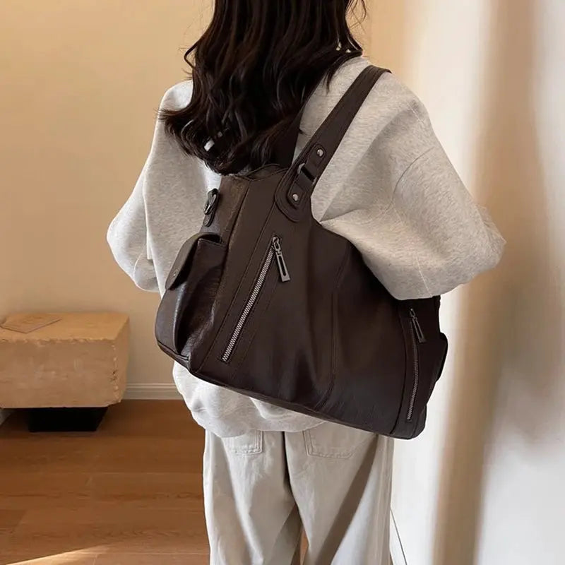 Soft interior compartment shoulder bag in brown PU leather with front zip pockets, crossbody style.