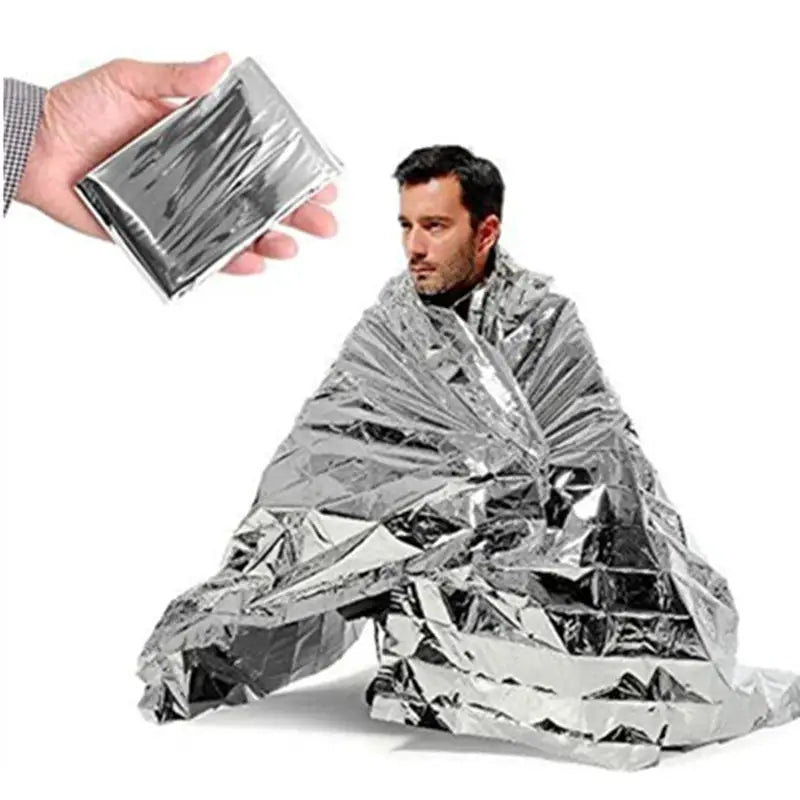 Simples Market Mylar emergency space blanket; metallic foil wrap on a person and a small compact pack (2 items).