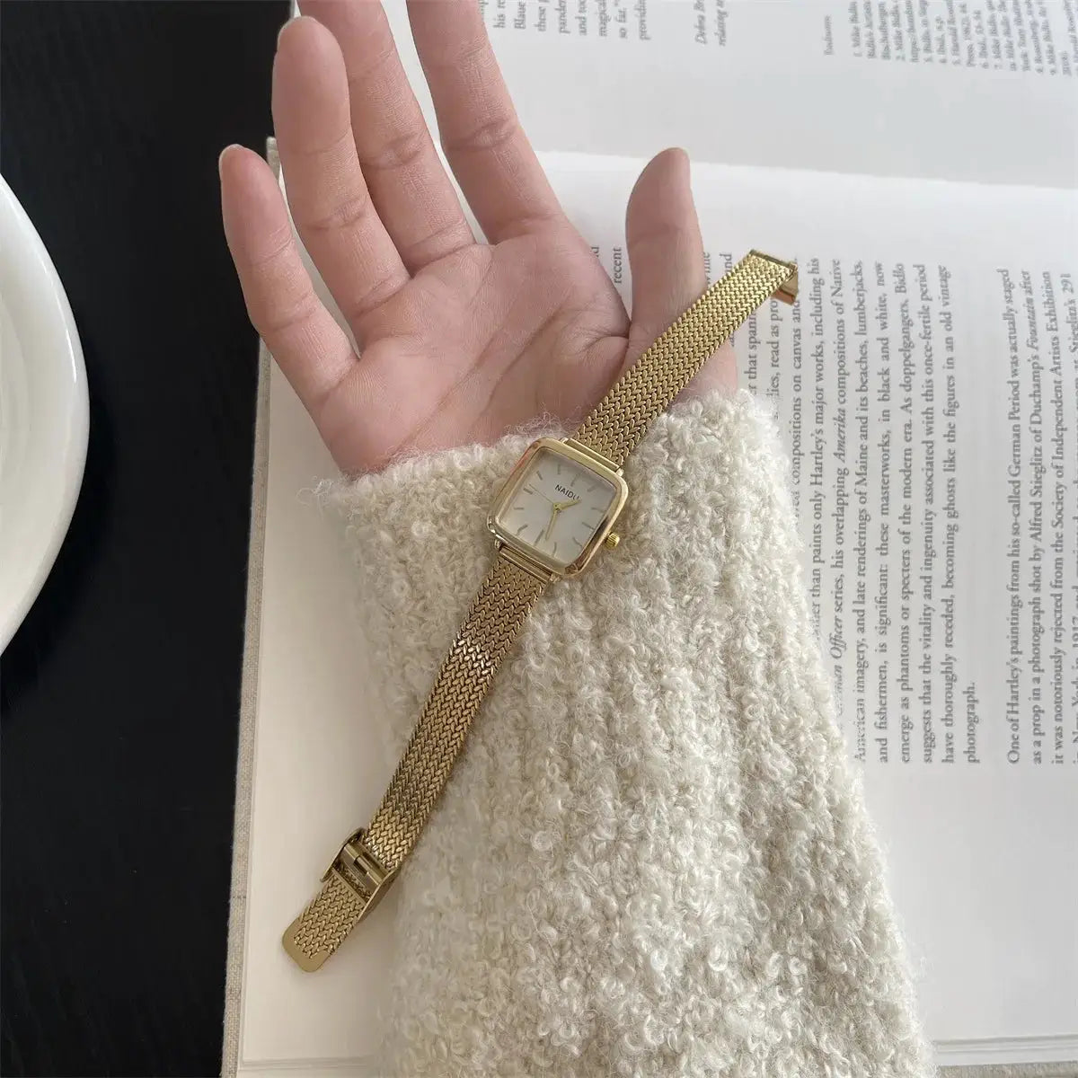 Gold-tone women's quartz watch with a small square dial and adjustable stainless steel mesh strap