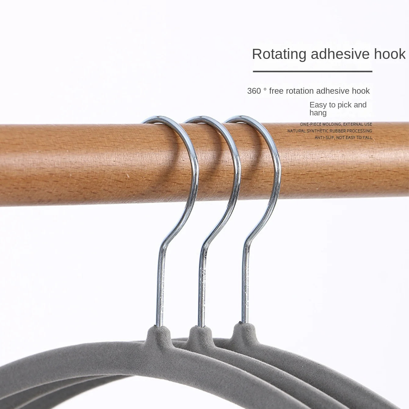 3 grey velvet hangers with metal hooks on a wooden closet rod
