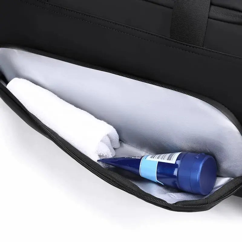 Simples Market sports gym bag; large black duffel with multiple compartments, towel and water bottle inside.