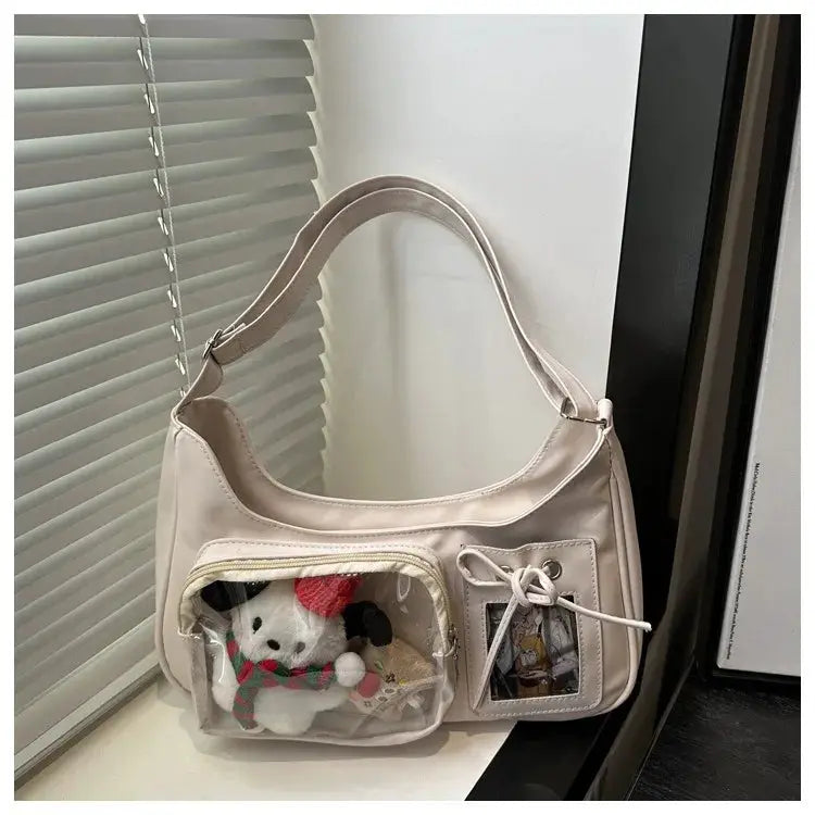 Y2k Harajuku shoulder bag in pale pink faux leather with clear front pocket displaying a plush toy